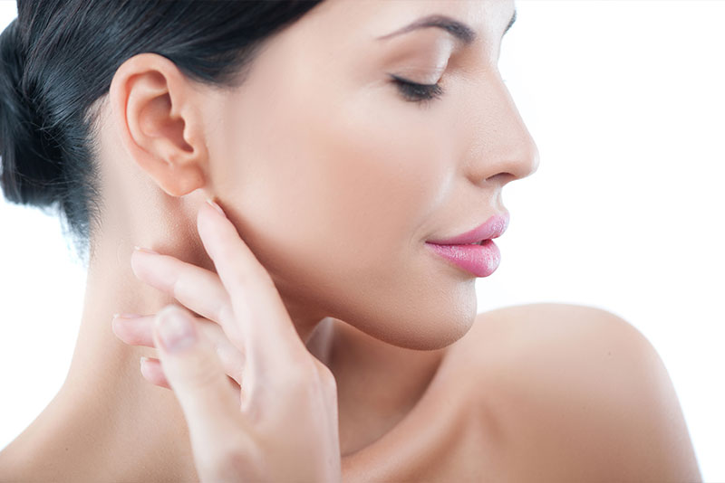 eine Frau berührt ihren Hals